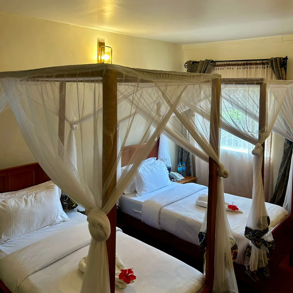 Double suite with two beds, wood finishes, and bright natural light.